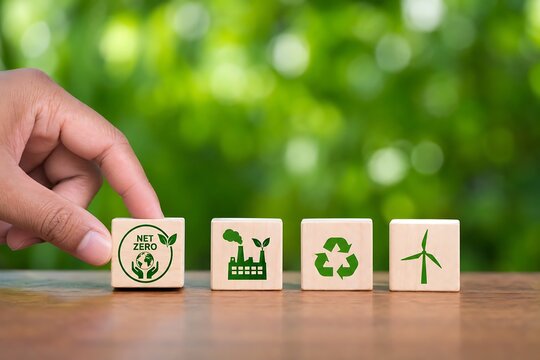 Hand placing wooden block with eco icons on table in green nature background
