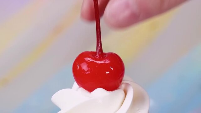 Placing a red maraschino cherry on whipped cream close up