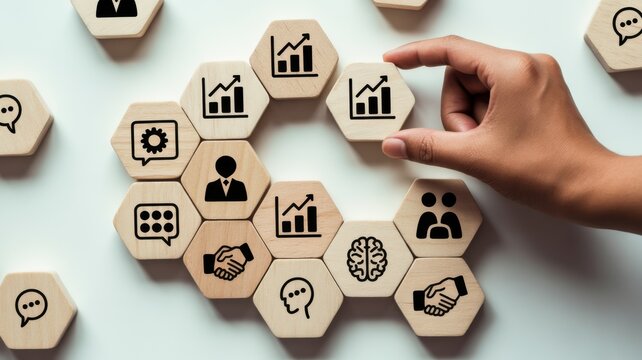 Hand arranging wooden blocks with business and career concept icons on light background