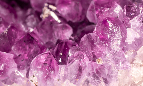 Amethyst purple crystals. Gems. Mineral crystals in the natural environment. Texture of precious and semiprecious stones. Seamless background with copy space colored shiny surface of precious stones.
