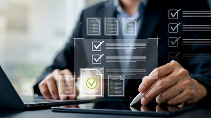 Fototapeta premium Businessman signing digital document on tablet with virtual checkbox interface