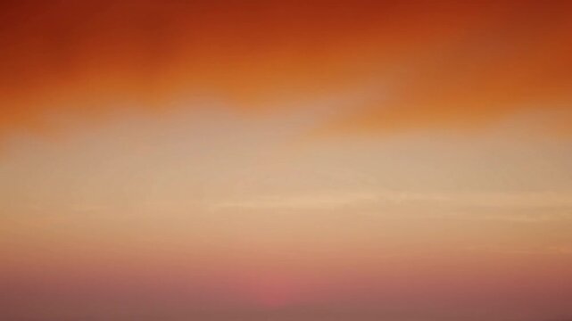 Serene sunset sky with dramatic clouds and warm orange and pink hues painting the horizon