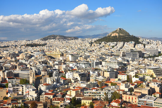 View to Athens cityscape and the Lykavitos hill with a big cloud in the sky. Greece. 
