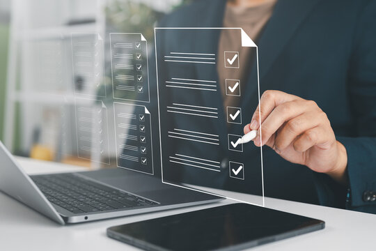 Businessman reviewed procedures and processes through a virtual online document with checkboxes, reviewing compliance with company policies, regulations, and terms and conditions.
