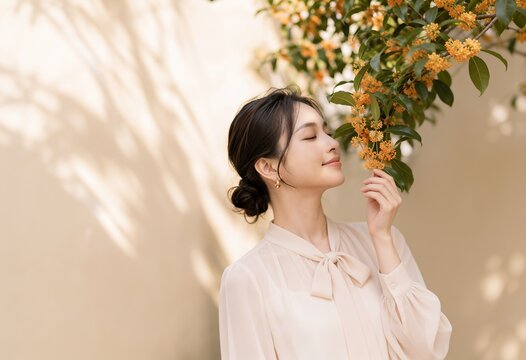 金木犀の香りを楽しむ若いアジア人女性の秋の美容イメージ