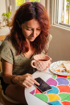 Woman scrolling her phone at home
