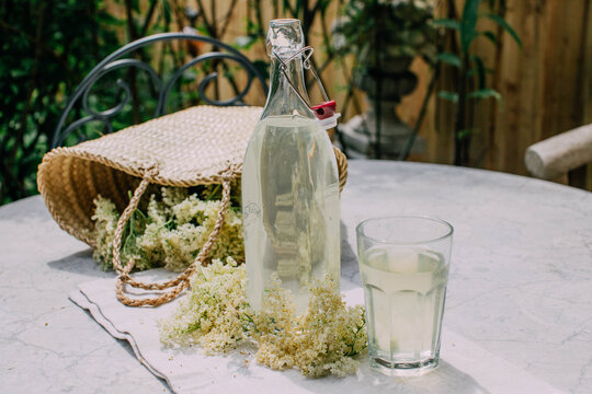 A Basket of Elderflower Next to Freshly Made Elderflower Cordial