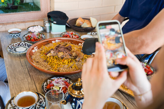 Person Taking Photo Of Pilaf at a Dining Table 