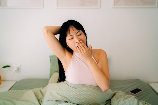 A woman stretching in bed