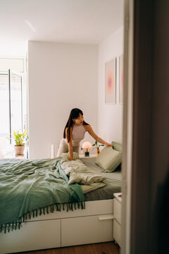 A woman spreading a bed