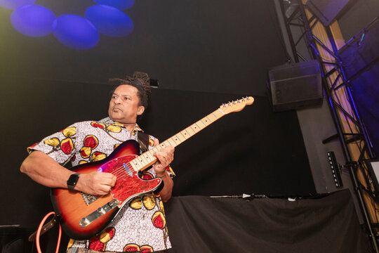 Musician performing live energetic guitar music on stage