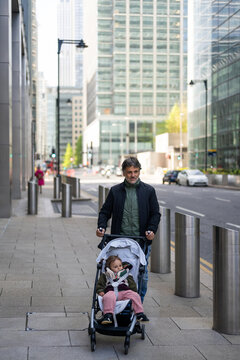 Father Taking Baby Girl For A Walk In London Business Area