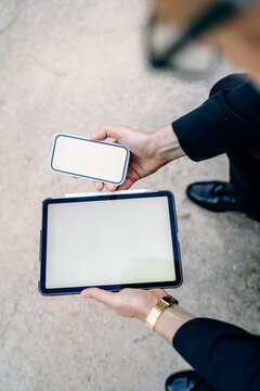 A man using a tablet and a mobile phone with white screens