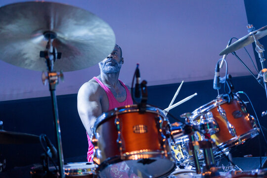 Male drummer performing live music on stage