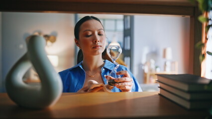 Asian woman dusting books shelf closeup. Tidying home decor weekend cleaning. © stockbusters