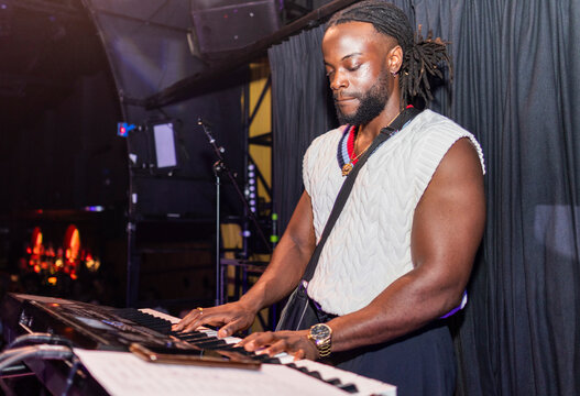 African american musician playing keyboard on stage during