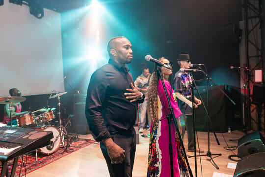 Musicians performing live music on stage under spotlight