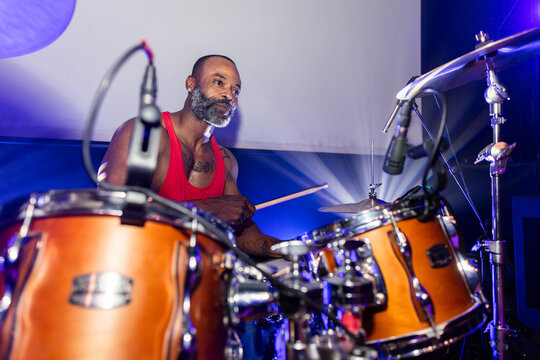 Drummer playing drums on stage during performance