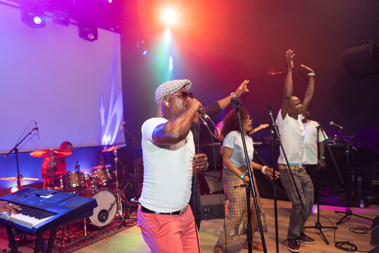 African ensemble performing live on stage with vibrant lighting