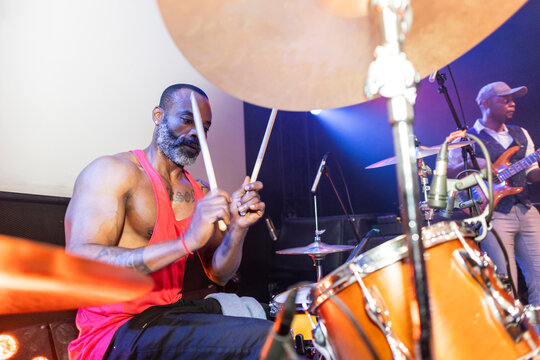 Black man drumming with passion during live concert