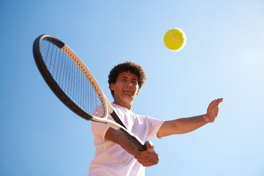 Young Man Plays Tennis With a Yellow Ball Under Clear Blue Sky