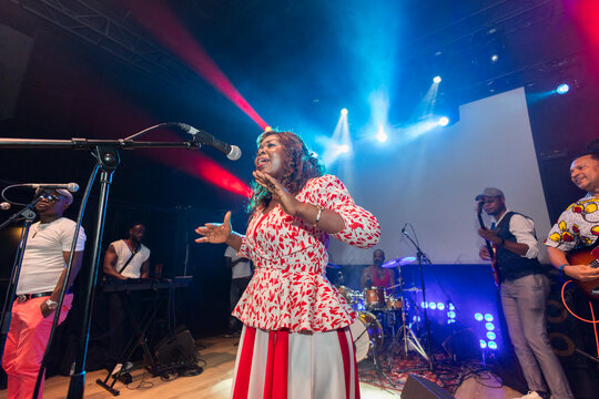Female singer performing live with music band on stage