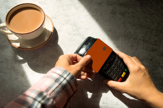 Anonymous woman's hand paying with a  credit card via a pos terminal.