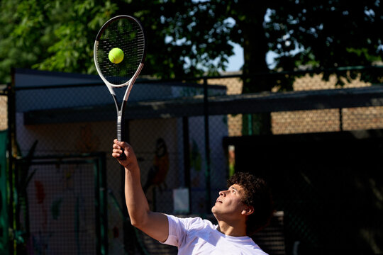 Tennis Player Serves Ball During Practice on a Sunny Day