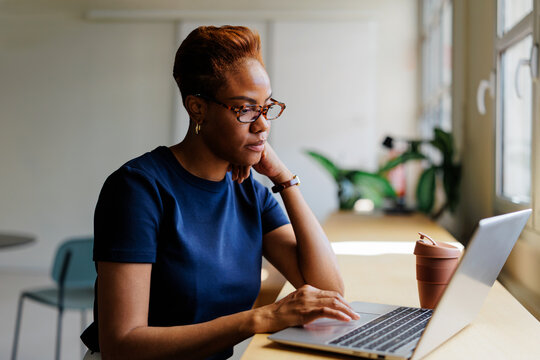 Professional woman concentrating on laptop in modern office