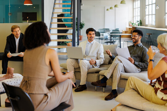 Businesspeople collaborating during meeting in modern office lounge
