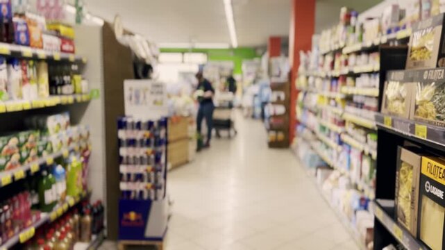 Out-of-focus background shot of a supermarket aisle with various products on shelves and anonymous customers walking in the distance, creating an abstract and generic shopping environment