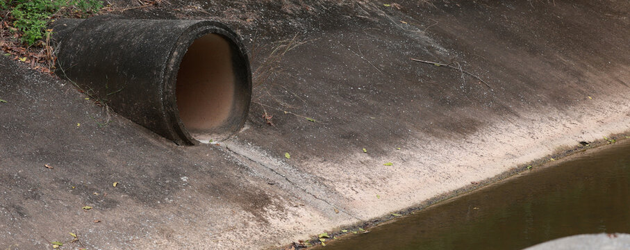 Concrete circular run-off pipe discharging water. sewage pipe polluting the river. Sewage or domestic wastewater or municipal wastewater that is product by community of people.
