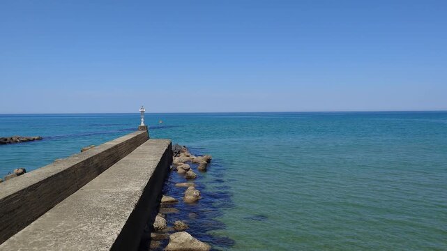 Perspective view of concrete breakwater leading out into turquoise ocean at Aoya coast, Tottori, Japan