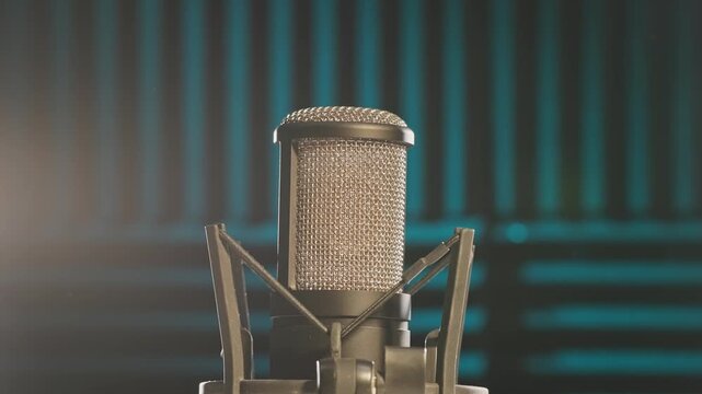 Slow motion colorful studio shot of voiceover dialogue podcast microphone on stand in close-up detail with acoustic foam in recording space with dark background and bright lighting of broadcast vo mic