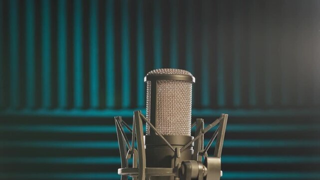 Slow motion colorful studio shot of voiceover dialogue podcast microphone on stand in close-up detail with acoustic foam in recording space with dark background and bright lighting of broadcast vo mic