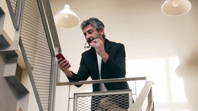 Video of smart businessman using smartphone in an elegant office