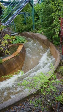Amusement park water channel beneath roller coaster tracks