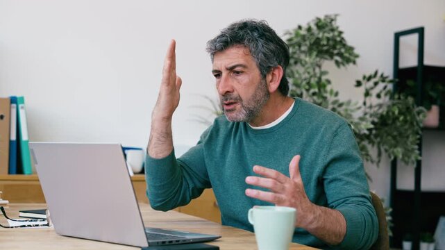 Video of frustrated man hitting his laptop while working in the office