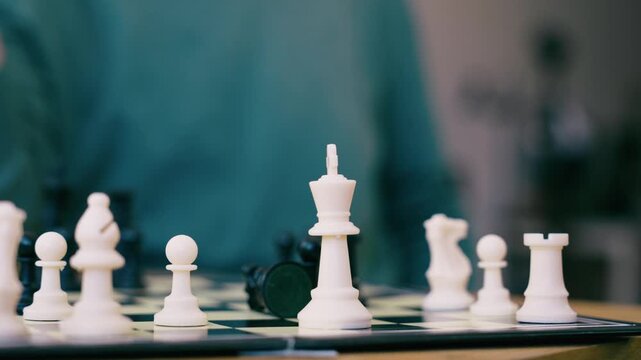 Video of close up of mature man playing chess with a friend at home