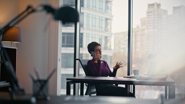 Confident entrepreneur phone conversation luxury office. Woman gesturing call