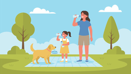 Naklejka premium Caring mother and daughter drink fresh bottled water while enjoying a picnic with their dog in a sunny park.