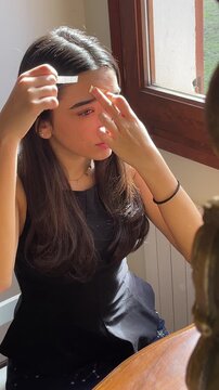 Woman performing face tapping massage as part of a natural skincare routine