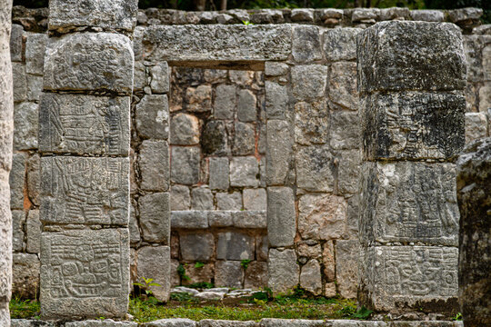 Close up of the carved stone columns framing a doorway with an altar in the background at the Xtoloc Temple ruins in Chichen Itza, Mexico