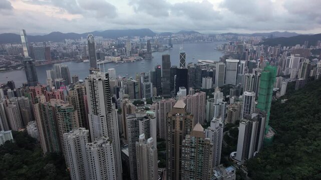 Panoramic high-angle view of Hong Kong city skyline, Victoria Harbour, and Kowloon from Victoria Peak