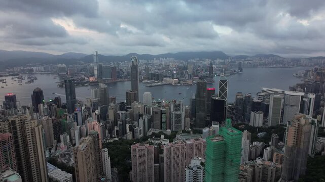 Panoramic high-angle view of Hong Kong city skyline, Victoria Harbour, and Kowloon from Victoria Peak