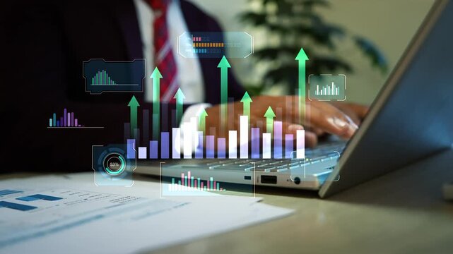 Businessman using a laptop with glowing hologram charts and rising arrows above financial reports animation on the screen, Business data growth analytics and digital planning in a modern office