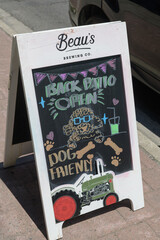 Obraz premium sidewalk a-frame chalkboard sign with brand marketing (Beau's Brewing Co) on Kingston Rd, Scarborough, Toronto