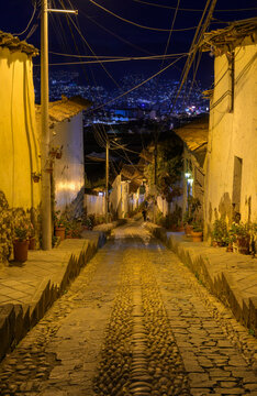 Night street in Cusco, Peru, climbing on a steep hill slope.