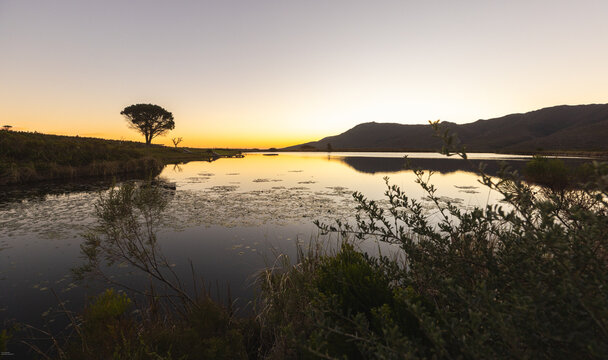 dusk falling on placid pond, Klein mountains in background, Stanford, South Africa