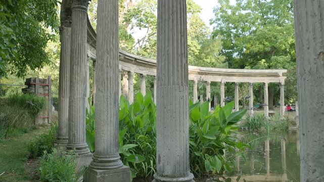 Low Angle View of Classical Corinthian Colonnade Along the Pond Edge with Camera Tilting Up